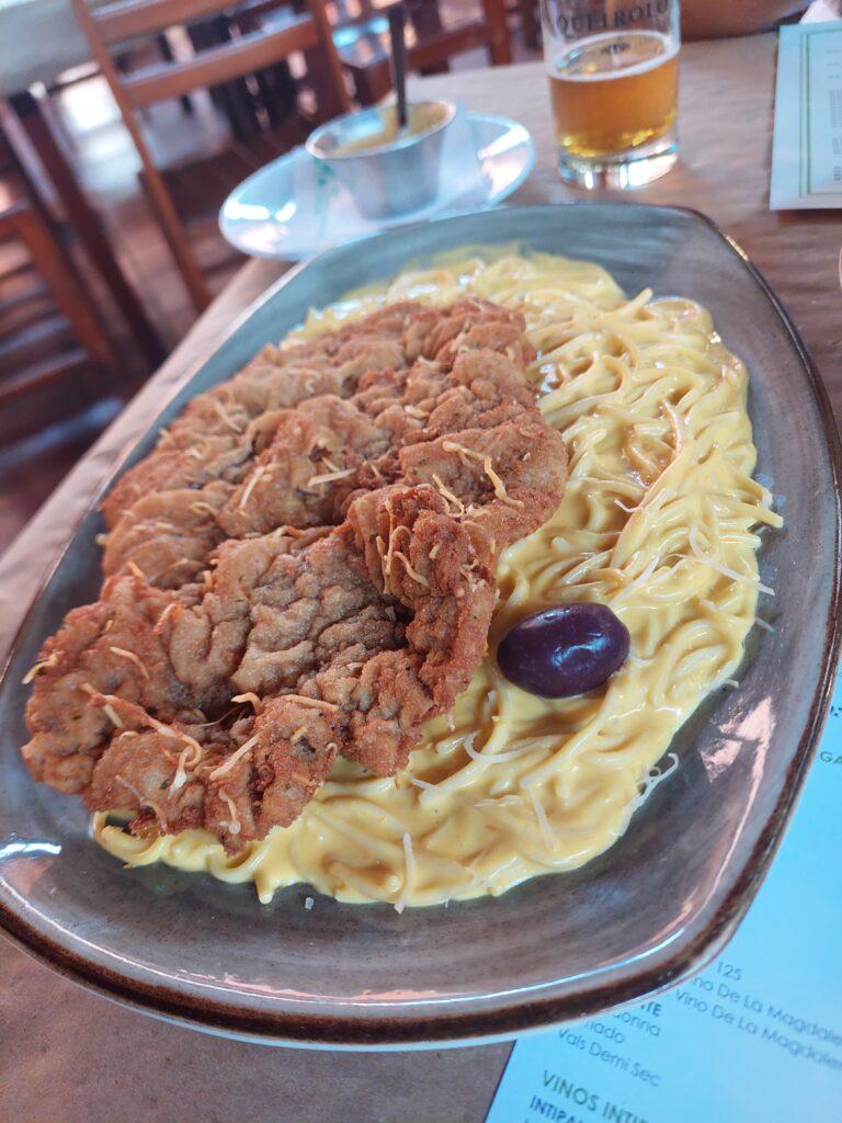 Plate of Tallarines en salsa a la Huancaína with bisteck apanado at Bolivariano Restaurant Pueblo Libre