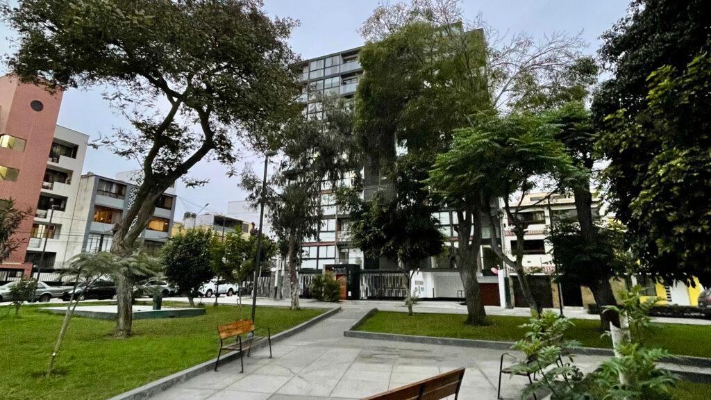Looking toward modern residential apartment buildings from the peaceful green space of Parque Daniel Hernandez in Colmenares.