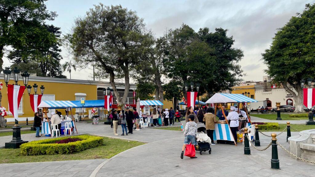 Traditional stalls set up in the heart of Plaza Bolívar, highlighting the vibrant community activity in central Pueblo Libre.