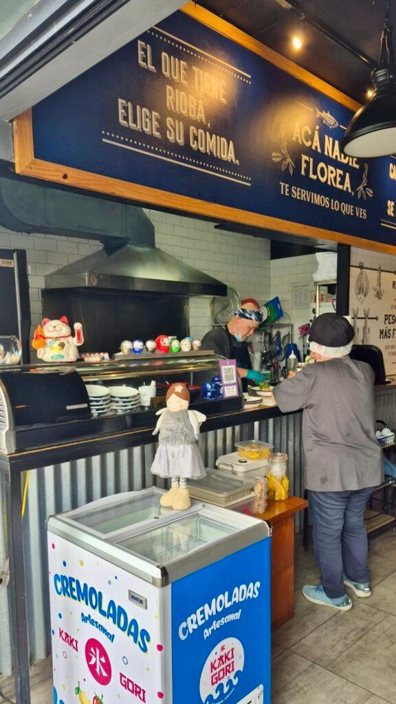 Chef and staff preparing Nikkei and Criollo fusion food inside the kitchen at Rioba 901.