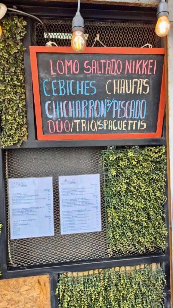 Handwritten menu board at Rioba 901 in Pueblo Libre featuring Nikkei and Criollo dishes.